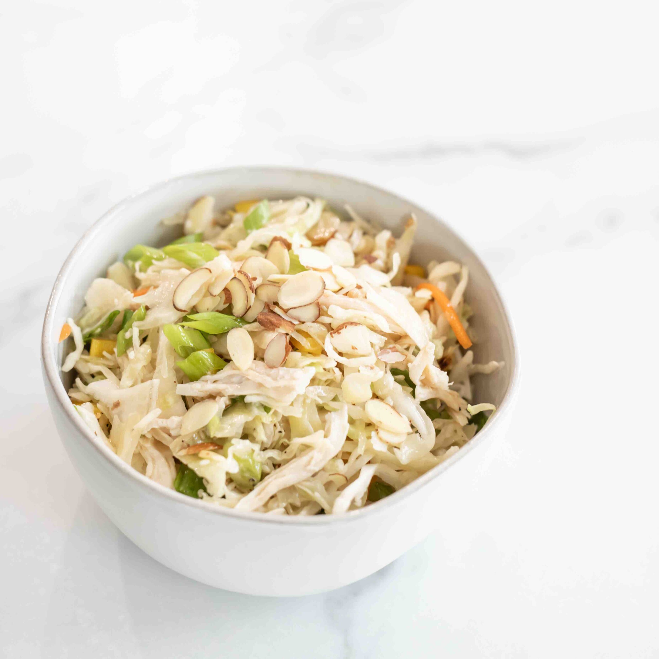 White bowl with asian chicken salad.