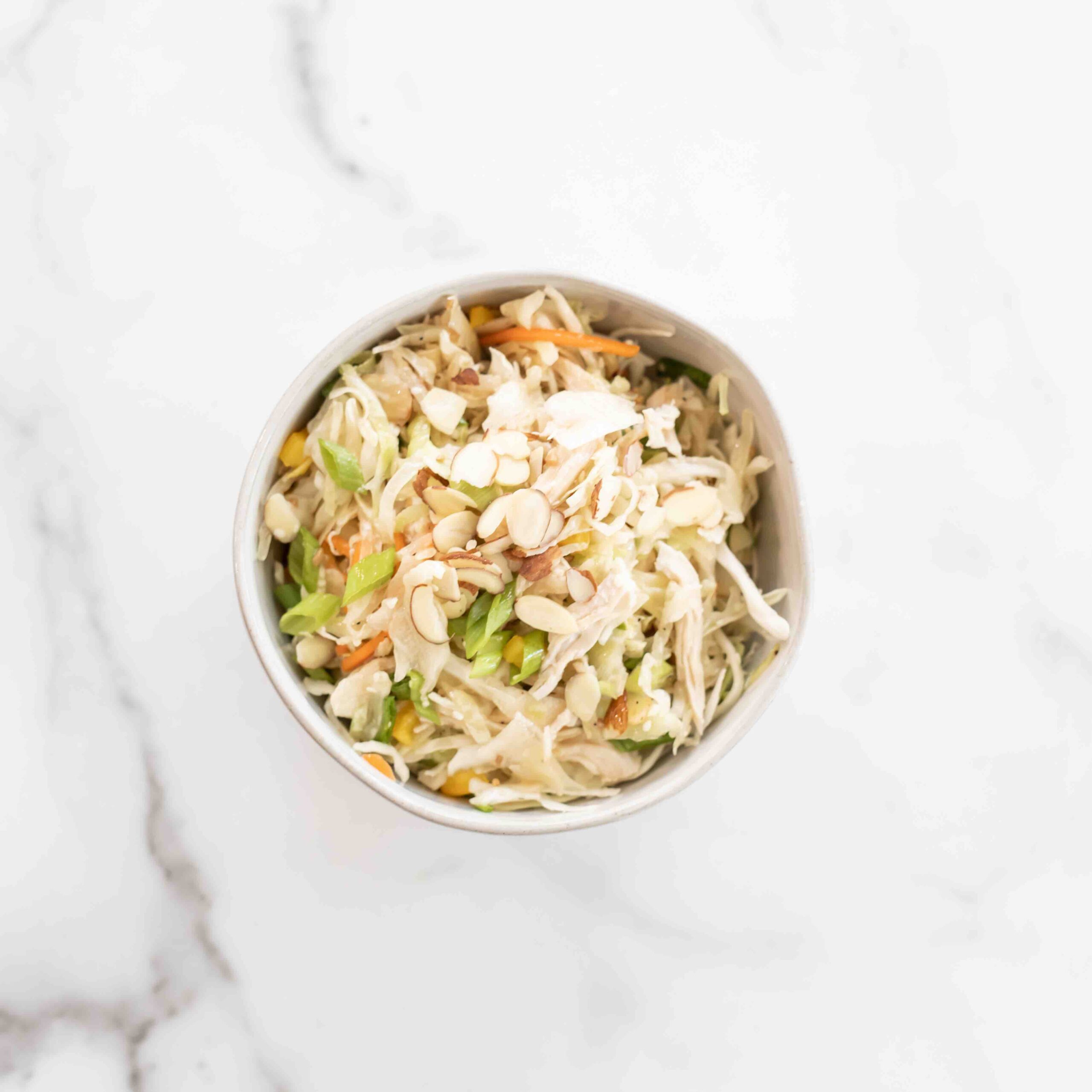 White bowl with asian chicken salad.