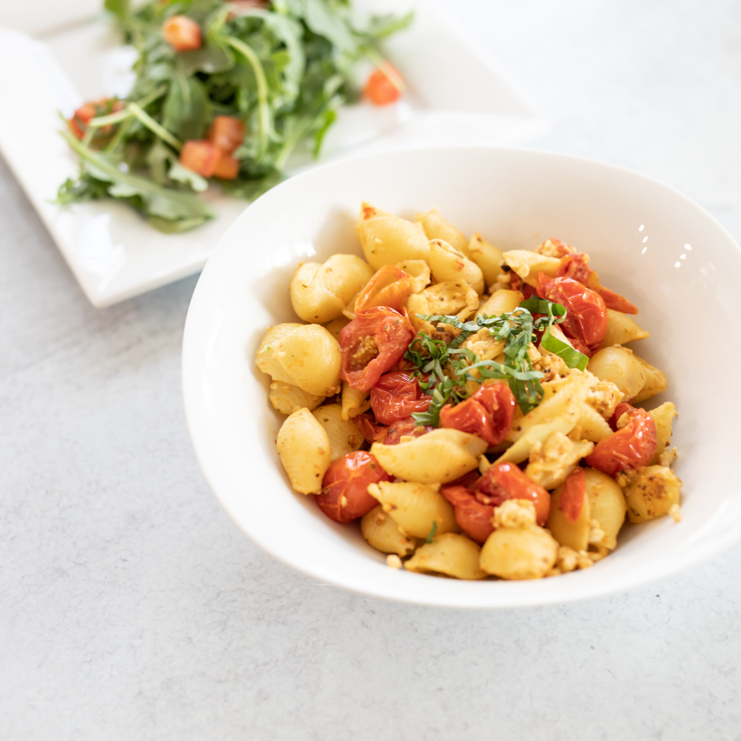 Salad and a Pasta dish with basil noodles and tomatoes