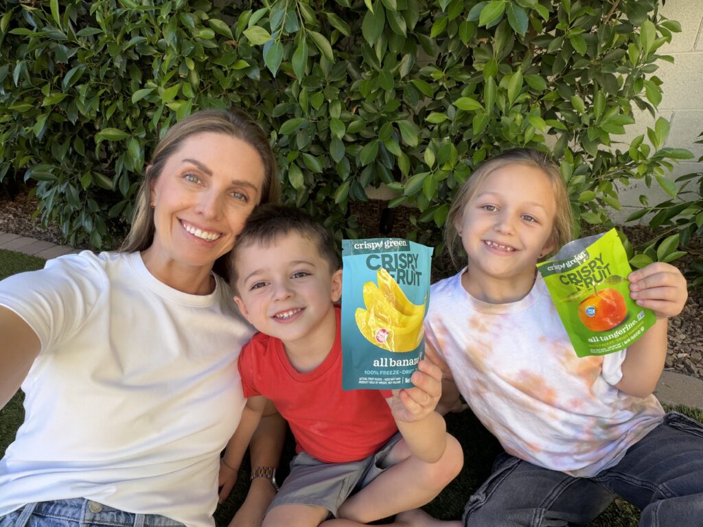 Gillean and two of her kids holding a bad of crispy chips